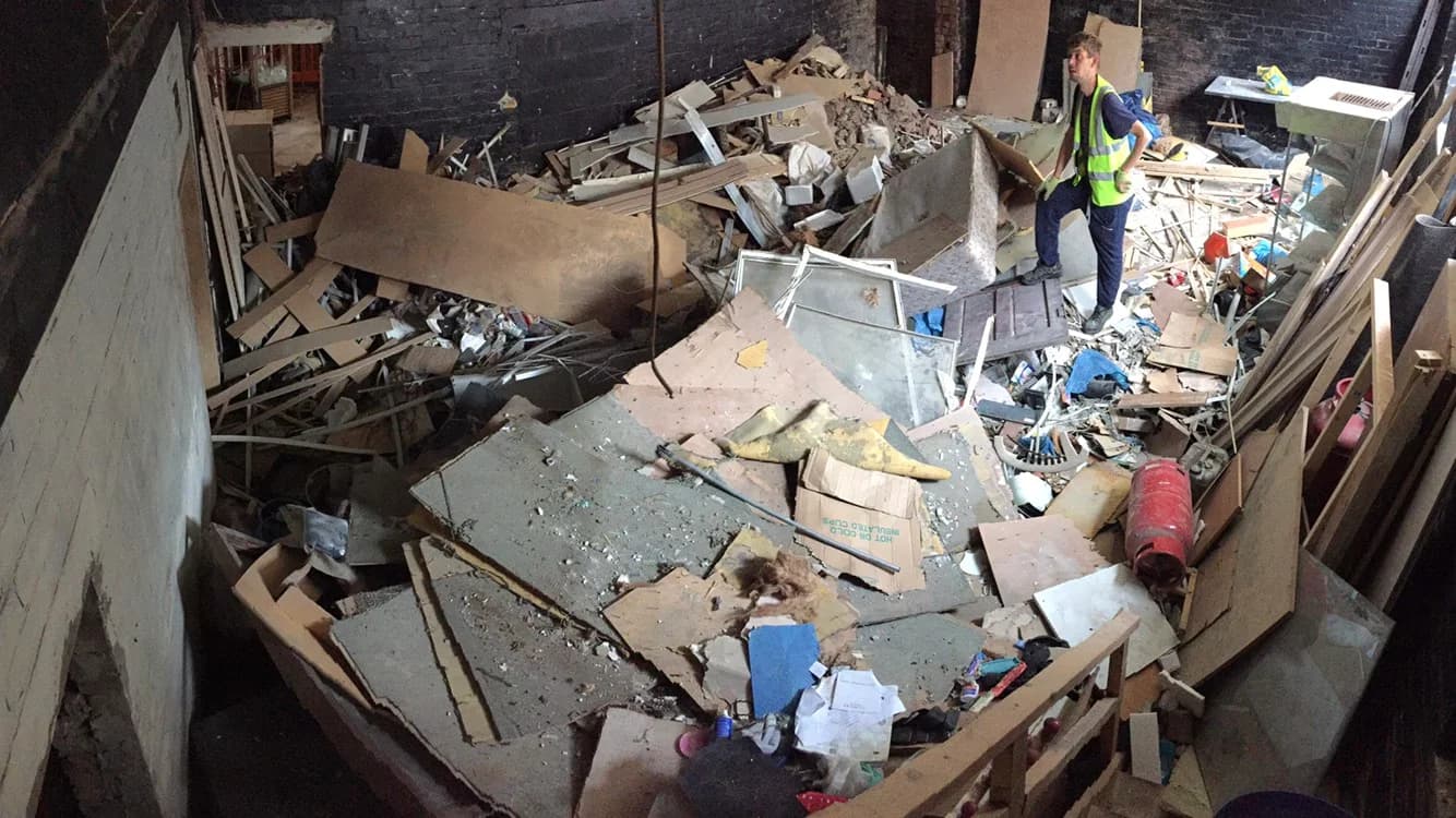 Waste Removers operative clearing mixed timber, plasterboard and fit-out debris from a commercial strip-out